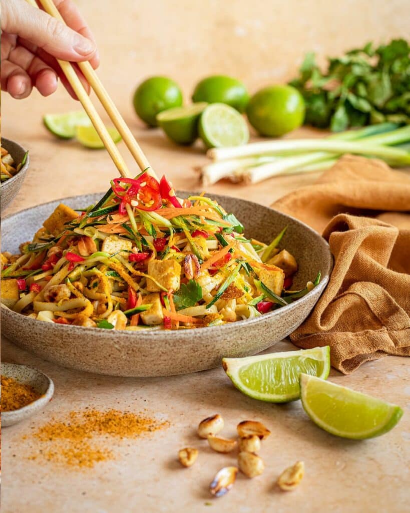 Das Foto zeigt eine Schüssel mit Pad Thai-Salat, angereichert mit "Food Finisher Asia Spice", serviert mit Stäbchen und garniert mit frischer roter Chili nach Rezept.